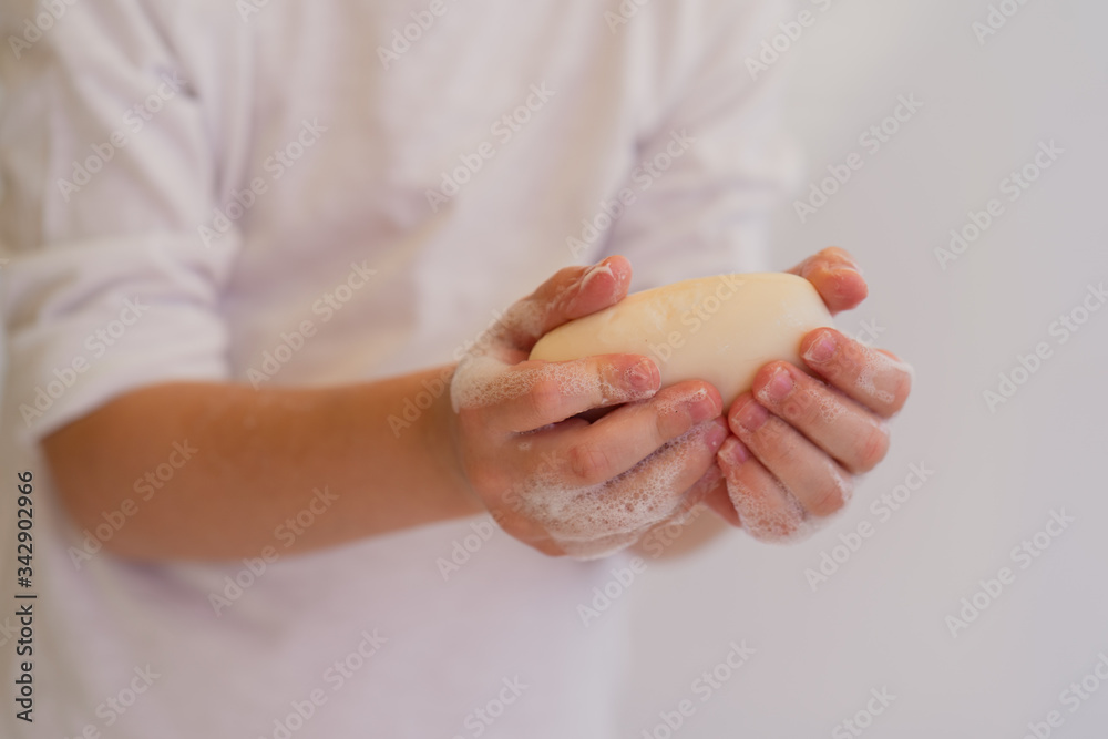 Baby washes his hands with white soap on a white background Baby washes his hands with white soap on a white background