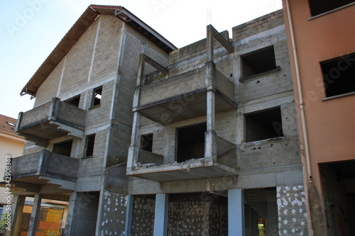 Floor building under construction. View of walls of cinder block. Foundation with reinforcement scrap. Window insert not installed yet. Site of an industrial contractor.