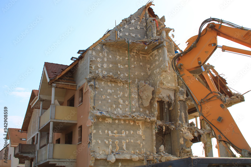 House being demolished. Construction equipment. Rubbs of a dilapidated building. Destruction for reconstruction in the city. Broken and open facade. House being demolished. Construction equipment. Rubbs of a dilapidated building. Destruction for reconstruction in the city. Broken and open facade.