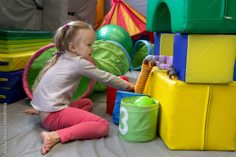 girl with a psychologist plays in colored soft cubes. preschool education girl with a psychologist plays in colored soft cubes. preschool education