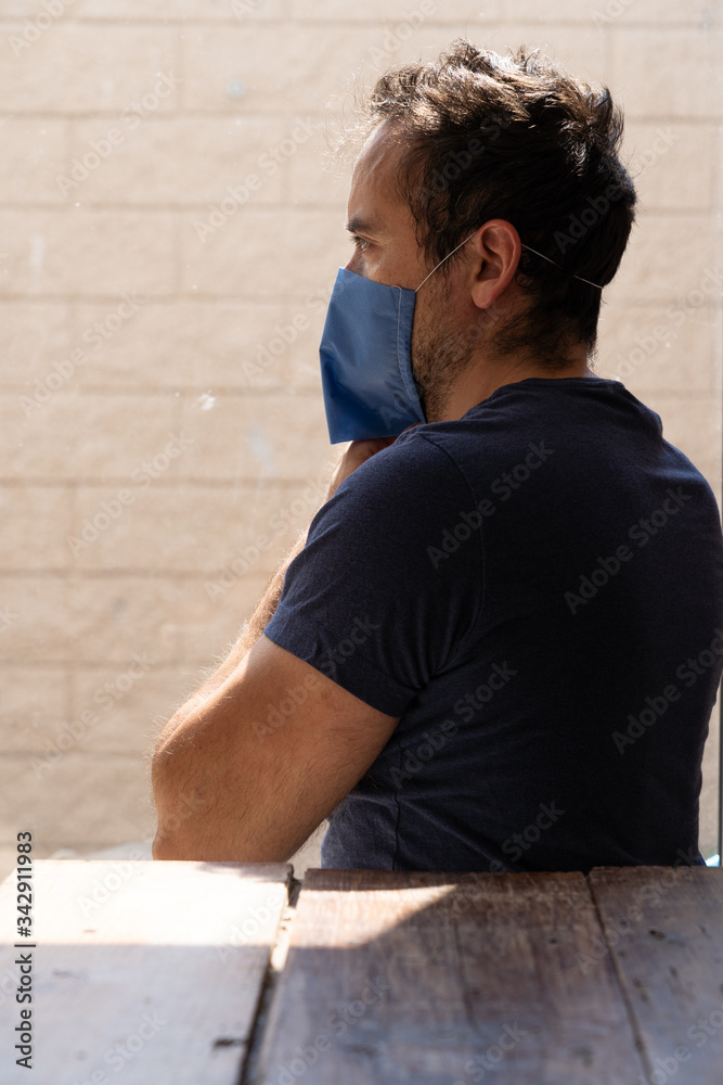 Staring outside while putting face mask on Staring outside while putting face mask on