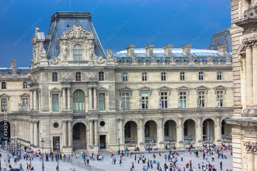 Louvre Museum in Paris, France, view on courtyard and tourists during the day, trip