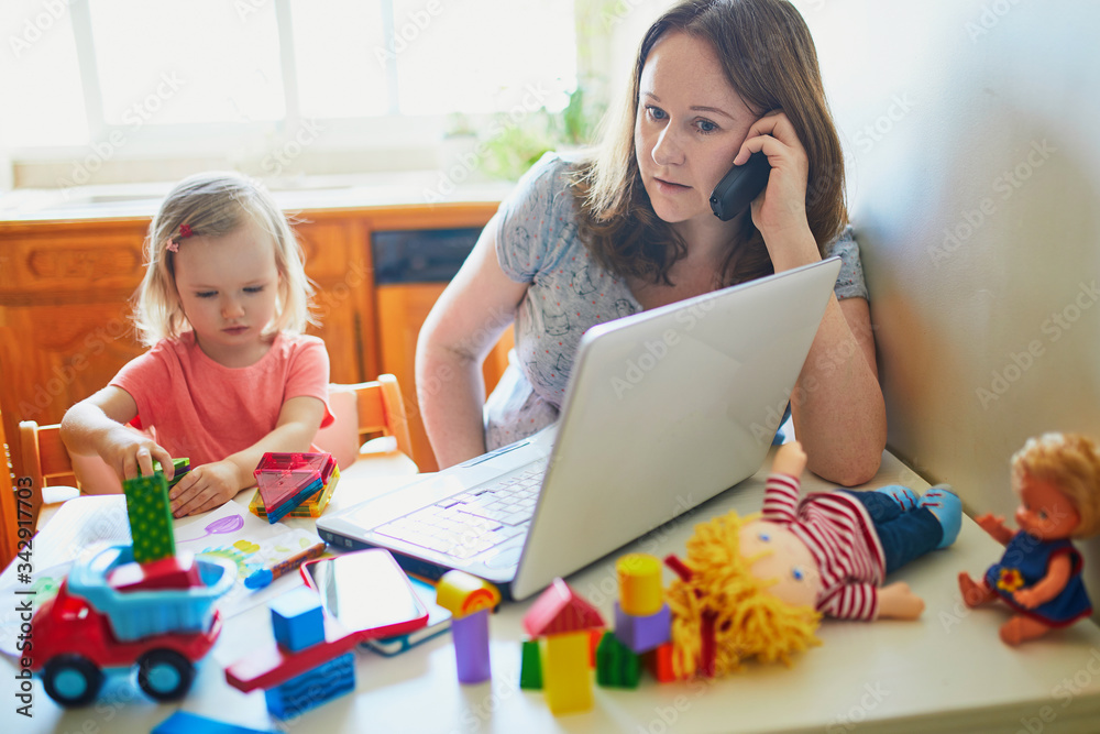Exhausted and stressed mother working from home with toddler Stock ...