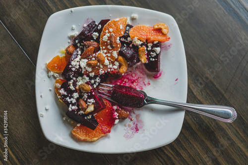 partially eaten plate of roasted beet salad with oranges and goat cheese