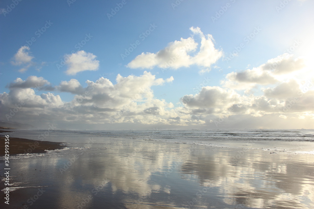 Reflecting Clouds on the Surf on Pacific Ocean at Manzanita Beach in Oregon