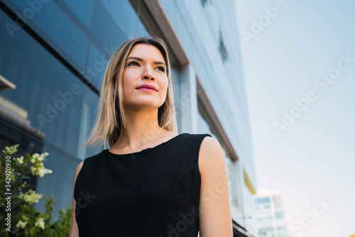 Business woman standing outside office buildings.