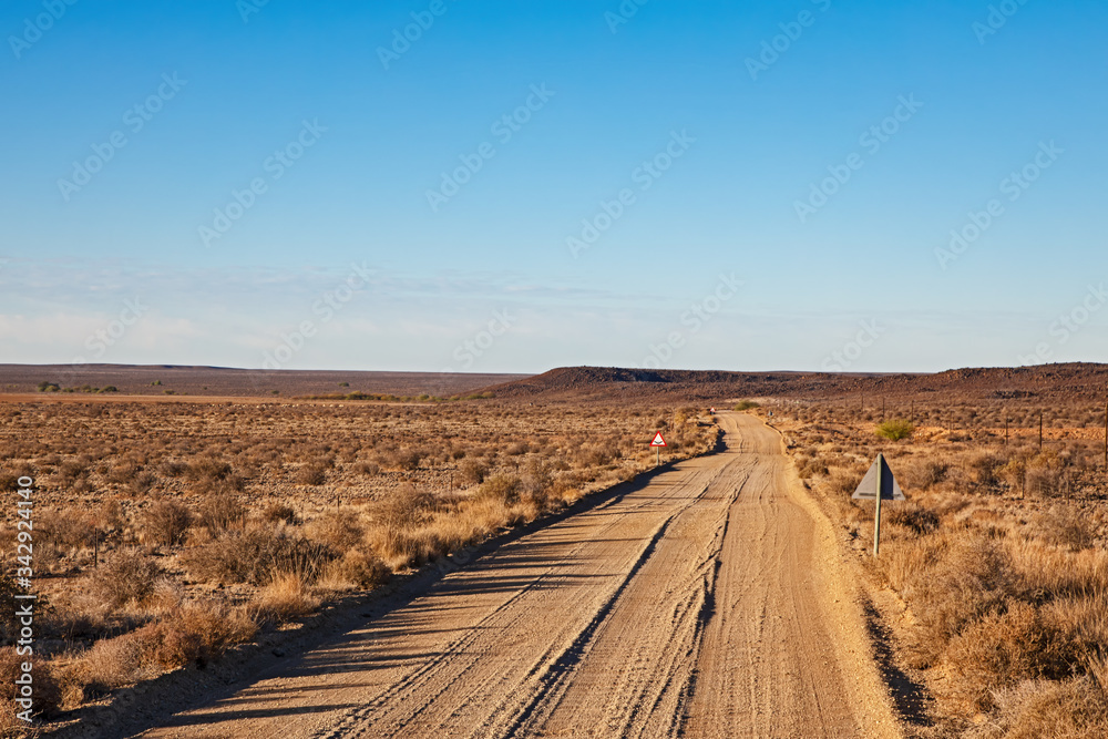 Corrugated gravel road with dip and curve in Karoo