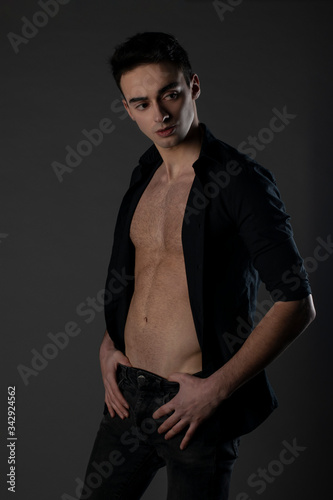 Sexy guy is posing on grey background.Studio Isolated. 