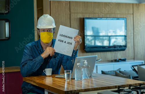Looking for a job. COVID-19. The unemployed man with sign LOOKING For A JOB. Unemployment during coronavirus COVID-19 crisis, the concept of job loss. 