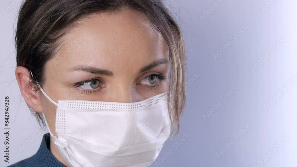 Portrait Beautiful young woman with tousled hair tired eyes in medical mask on a white background close-up view. Nurses, medical staff during epidemic. Health care Coronavirus and medical concept Portrait Beautiful young woman with tousled hair tired eyes in medical mask on a white background close-up view. Nurses, medical staff during epidemic. Health care Coronavirus and medical concept