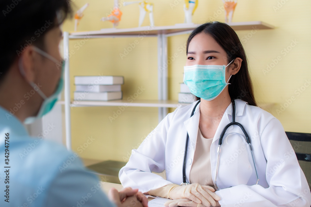 Selective focus. Asian doctors wearing surgical masks. Wearing doctor gown protective suit and stethoscope Consulting with patients. Blurred image rear view patient foreground
Selective focus. Asian doctors wearing surgical masks. Wearing doctor gown protective suit and stethoscope Consulting with patients. Blurred image rear view patient foreground