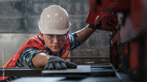 industrial background of caucasian mechanic engineer checking precision of steel plate cutting machine in metal work and machine part manufacturer factory and workshop