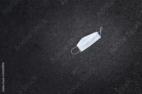 A discarded medical face mask lying on the pavement during the Covid 19 pandemic.
