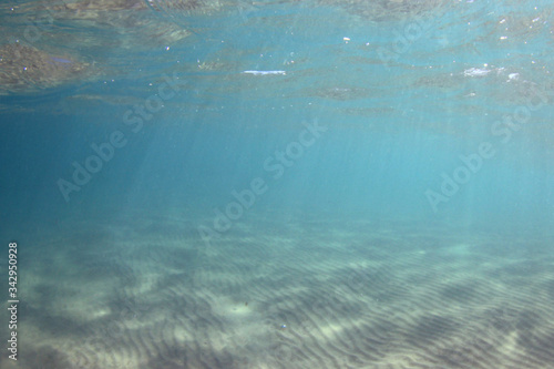 Underwater sea with blue water and sand bottom 