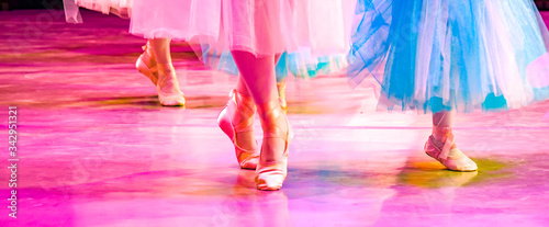 colorful ballet, female legs in pointe shoes on stage, large, blue and pink ballet tutus