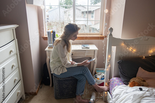 Young woman at home looking at her mobile phone
