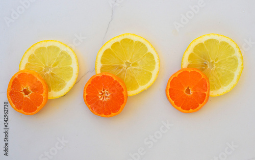 orange and lemon slices on a white marble background