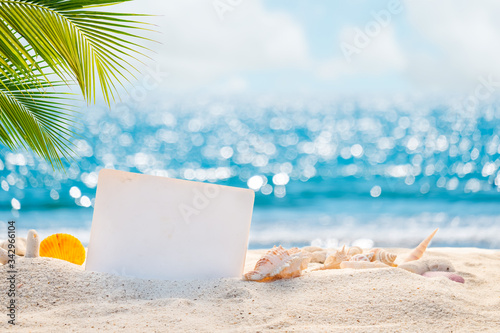Sandy beach with empty paper card for message design. blur sea on background. Tranquil beach scene for travel inspirational. Summer exotic holiday and vacation concept for tourism relaxing.