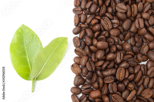 Raw coffee beans with leaf on white background.