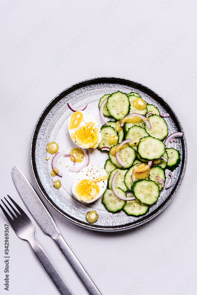 Easy vegetarian salad with cucumber, onion and eggs with vinaigrette sauce. Healthy nutrition. Selective focus Easy vegetarian salad with cucumber, onion and eggs with vinaigrette sauce. Healthy nutrition. Selective focus