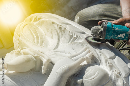 Fotografie Burmese stone engraver uses a marble grinding machine to carve white marble a Bu