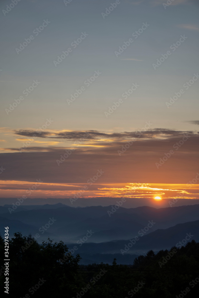 霞が掛かる山並みの日の出の風景