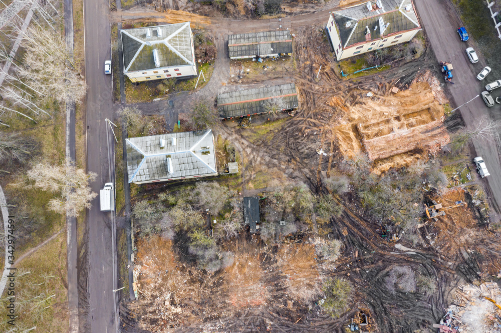 heavy excavator working at demolition site in ruins of old buildings. aerial drone photo looking down