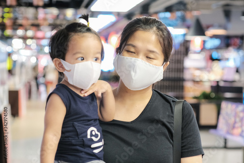 Mother carrying little boy shopping in supermarket wear n95 mask protect COVID 19