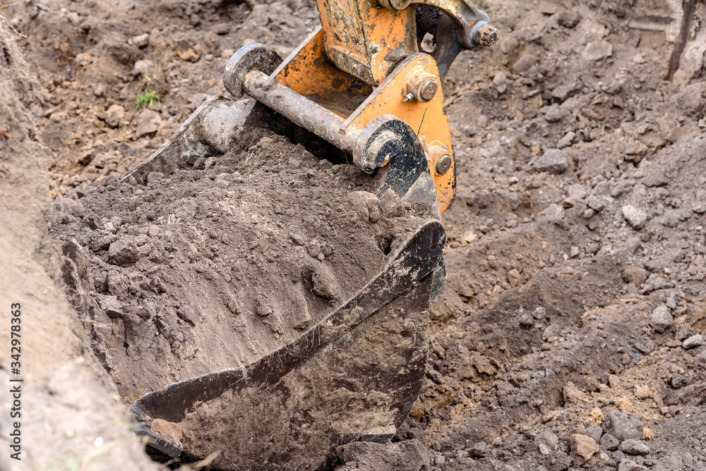 The modern excavator performs excavation work on the construction site The modern excavator performs excavation work on the construction site