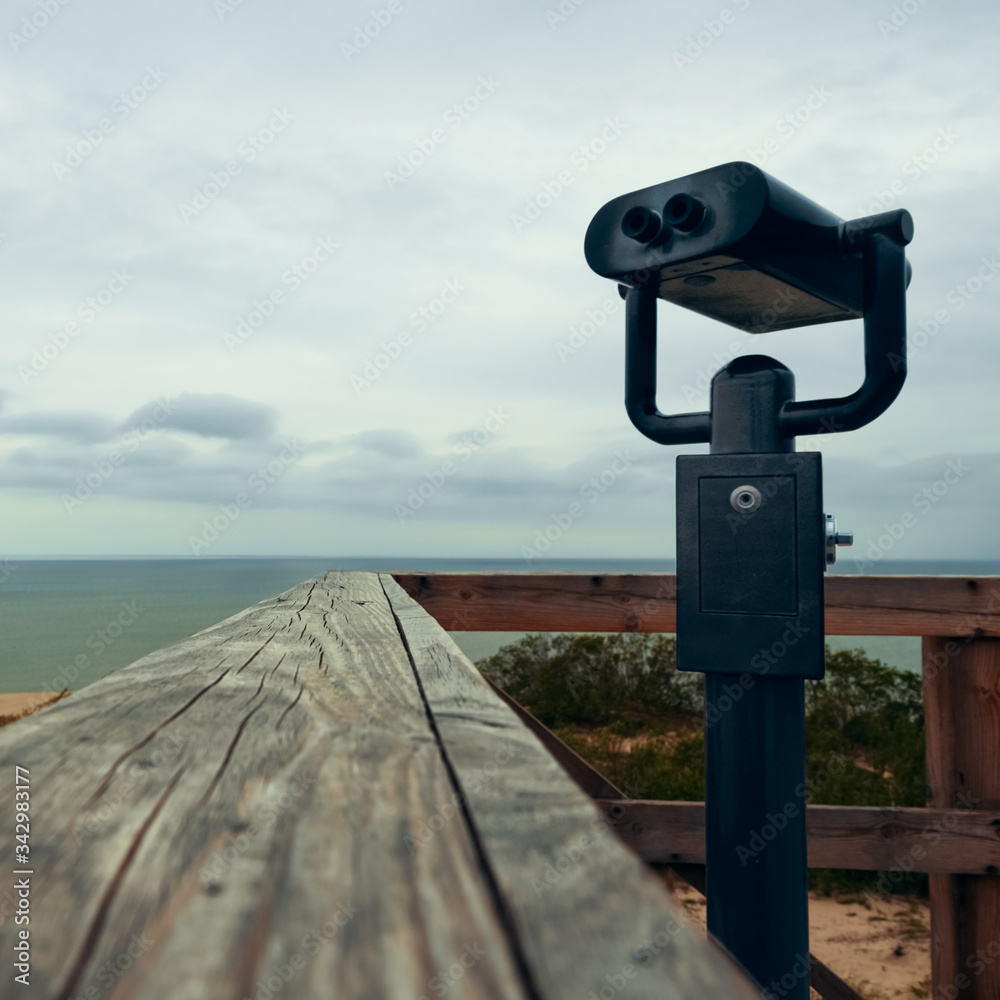 Binoculars for the observation deck on the beach at the wooden railing