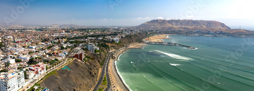 Panoramic aerial view of Lima's shoreline including the districts of Barranco and Chorrillos, with "Morro Solar" on the background. Clear ocean and bright day  © MyriamB