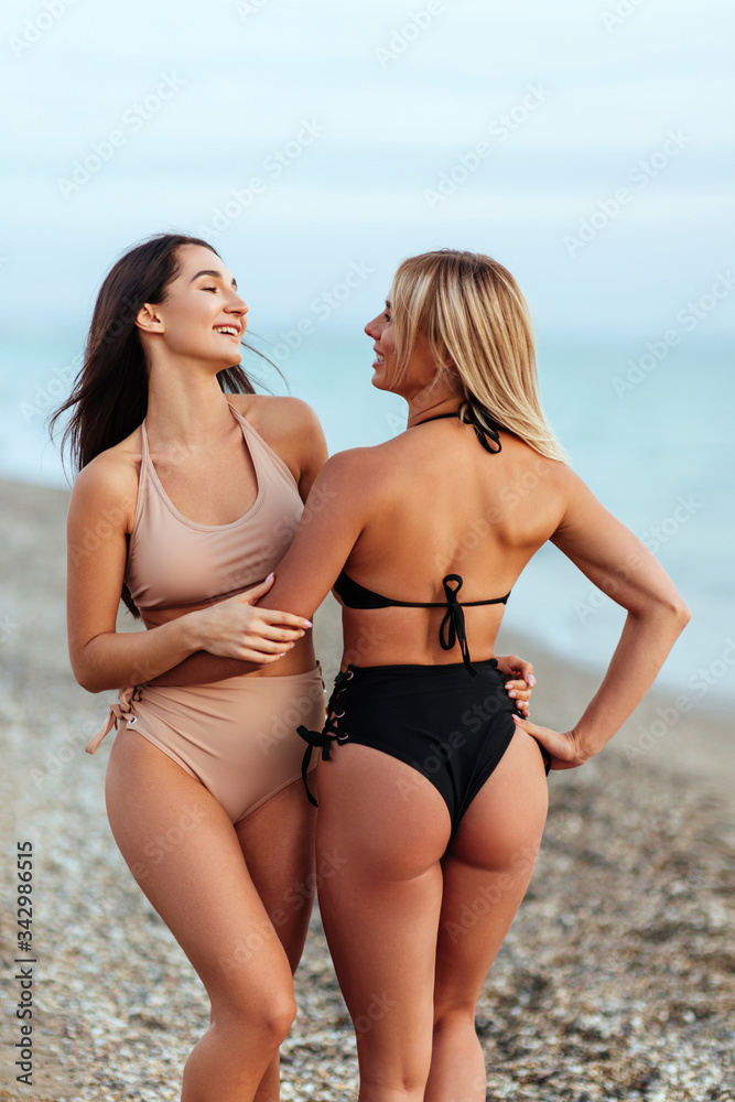 Two amazing tanned girls on the beach