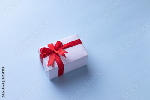 Fototapeta Naklejka Na Ścianę i Meble -  White gift box with red ribbon, black background flat lay for stock image
