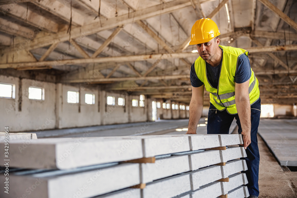 Blue collar worker doing his job at construction site. Blue collar worker doing his job at construction site.