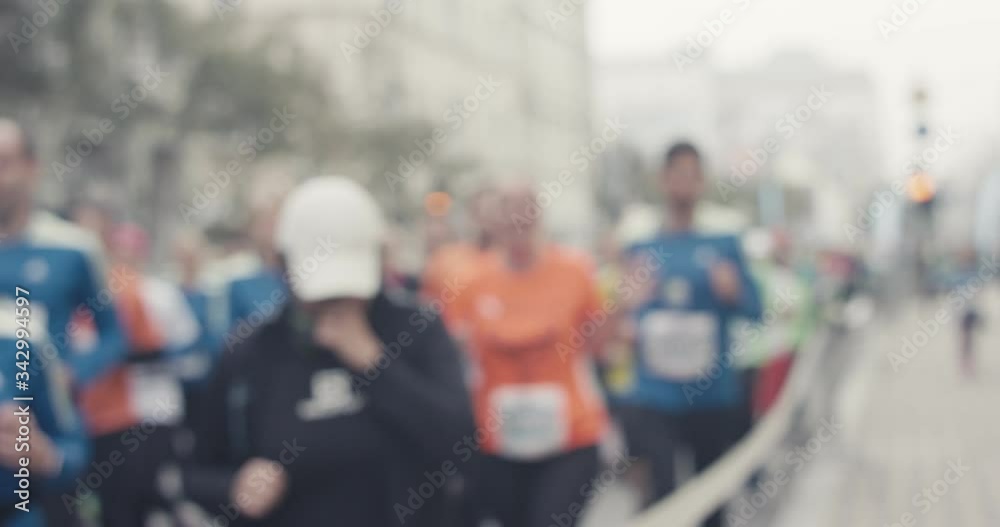 Marathon runners of multi generations waving on a foggy day in urban city center before pandemic unrecognizable front view medium shot