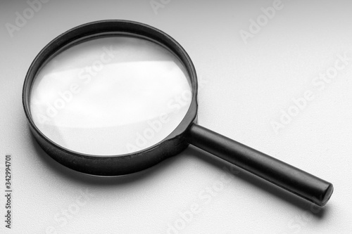 A black magnifier lies on a white windowsill.