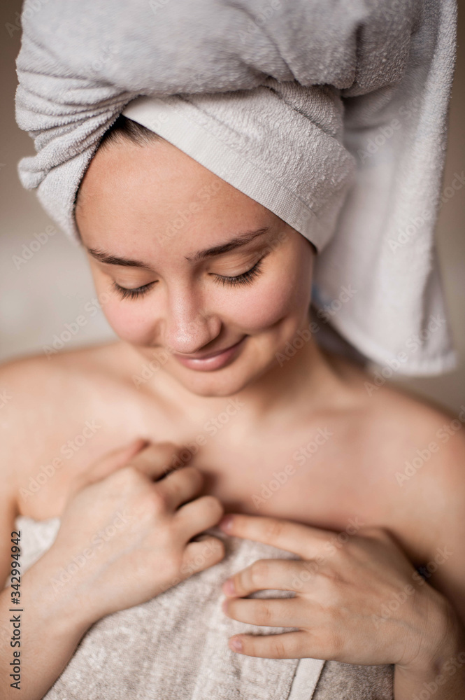 brunette girl without makeup with problem skin naked wrapped in a towel after a bath doing Spa treatments brunette girl without makeup with problem skin naked wrapped in a towel after a bath doing Spa treatments