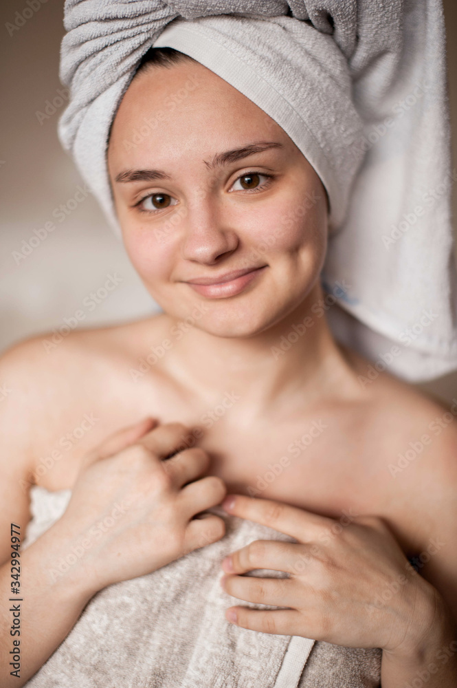 brunette girl without makeup with problem skin naked wrapped in a towel after a bath doing Spa treatments brunette girl without makeup with problem skin naked wrapped in a towel after a bath doing Spa treatments