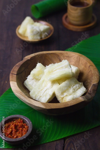 Boiled cassava on rustic bowl. Served with "sambal or chili sauce.
