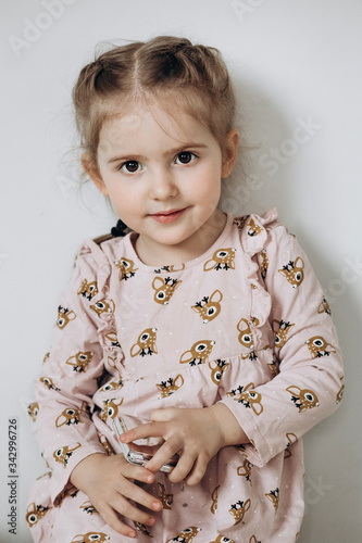 Close-up portrait of a little three year old girl on a white background