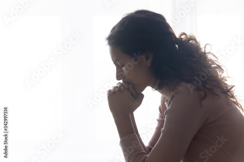 Side view head shot frustrated woman suffering from loneliness at home. Nervous young lady thinking of hard decision, feeling desperate indoors, overcoming grief alone, need psychological support.
