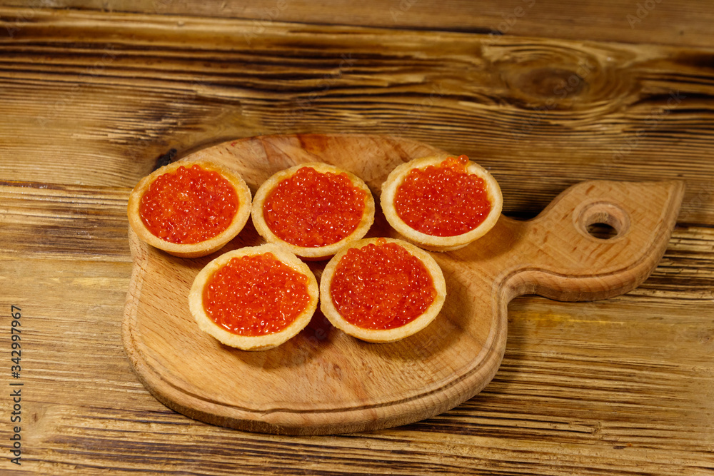 Tartlets with red caviar on a wooden table Tartlets with red caviar on a wooden table