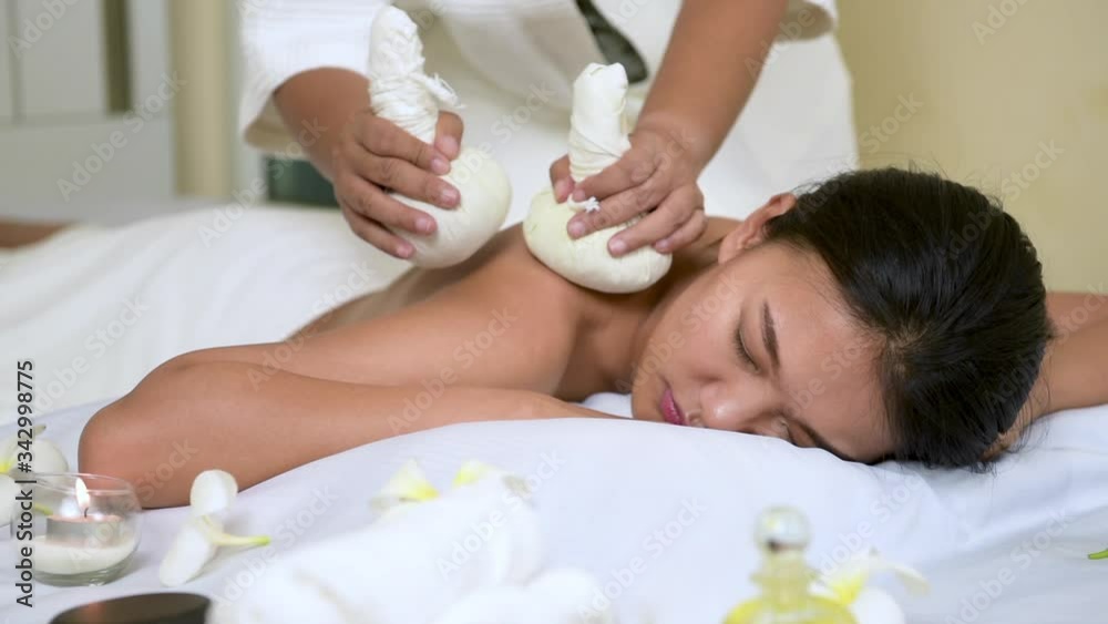 women relaxing with thai massage by Thai Herbal compresses. Masseuse doing massage on Asian woman back body in the spa salon. Spa products is oil, candles, salt, and massage with spa herbal balls women relaxing with thai massage by Thai Herbal compresses. Masseuse doing massage on Asian woman back body in the spa salon. Spa products is oil, candles, salt, and massage with spa herbal balls
