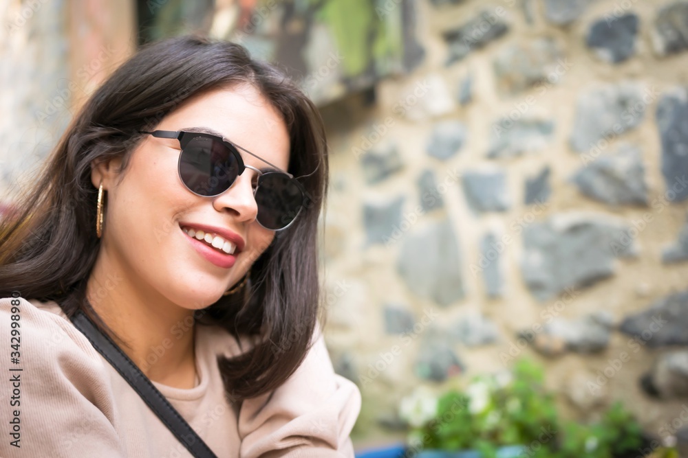 Portrait of young beautiful girl with red lips and sun glasses from middle east country Tunisia is posing to photographee. Blank space and rocky wall background. Portrait of young beautiful girl with red lips and sun glasses from middle east country Tunisia is posing to photographee. Blank space and rocky wall background.