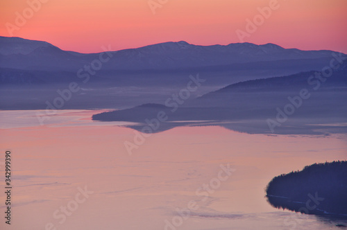 夜明けの湖、山並みのシルエット。屈斜路湖、北海道、日本。