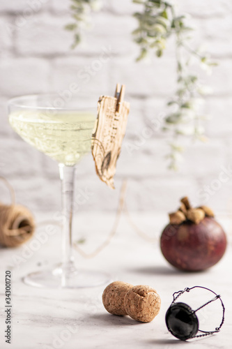 Blured glass of champagne, mangostin and cork. Still life photo