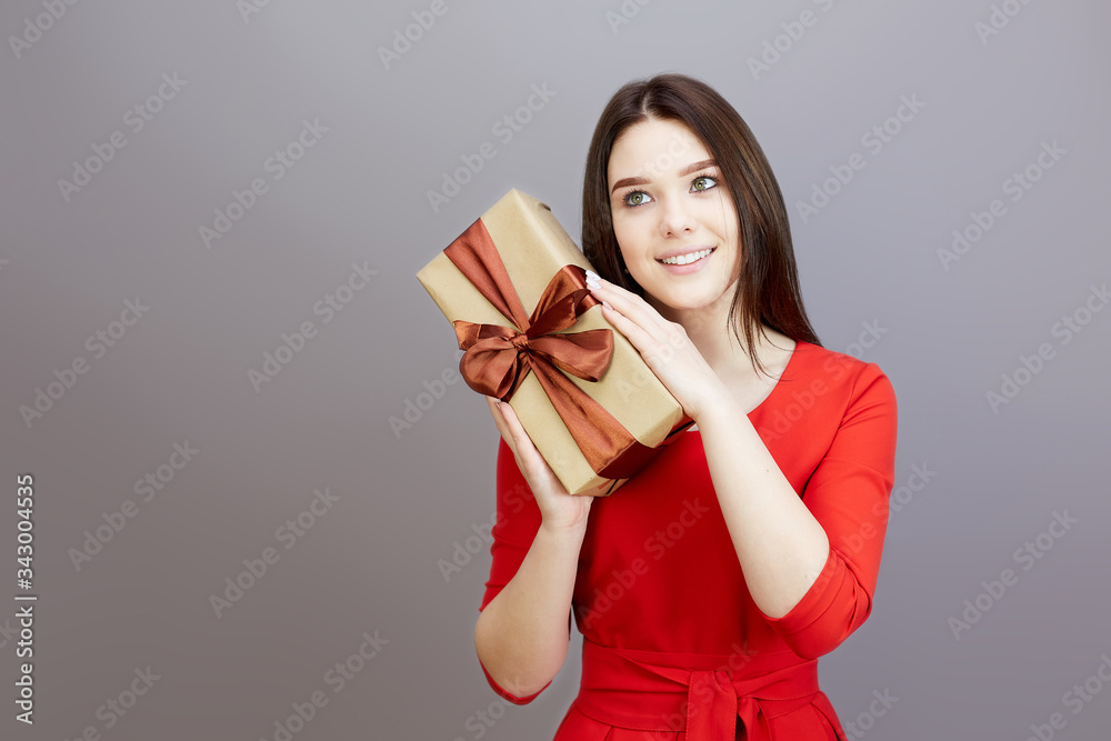 Girl in a red dress celebrates a birthday. Brunette teen girl in a bright red dress receives gifts for the holiday. Girl in a red dress celebrates a birthday. Brunette teen girl in a bright red dress receives gifts for the holiday.