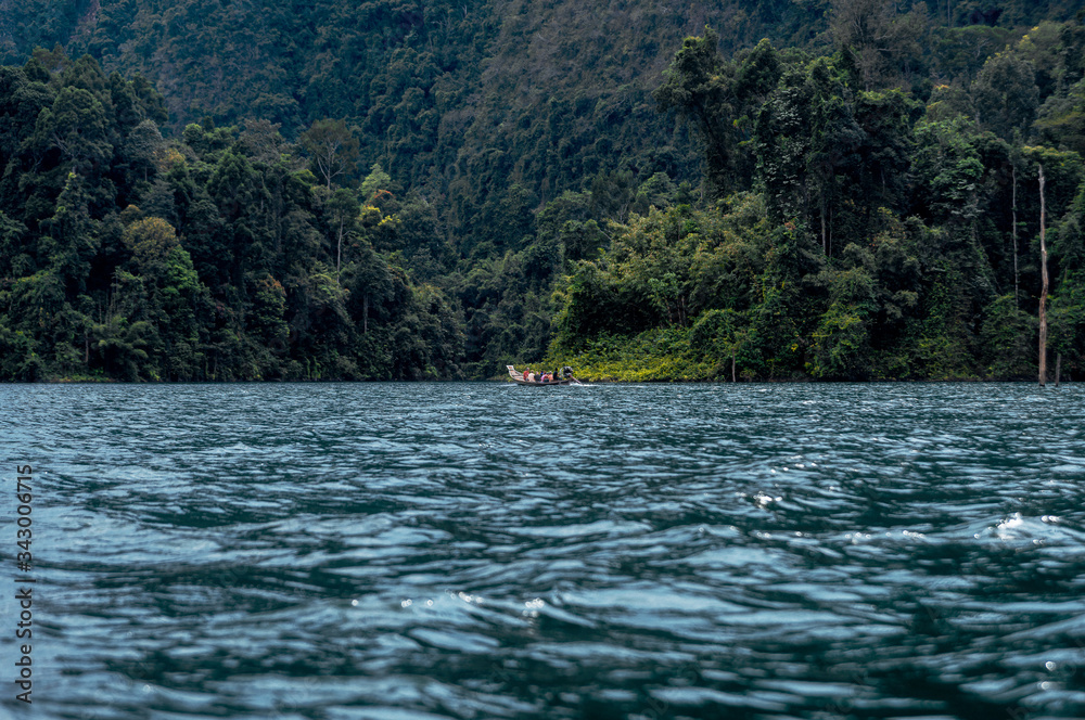 Boat with tourists on the background of the tropics. Khao Sok National Park and Cheo Lan Lake. Thailand