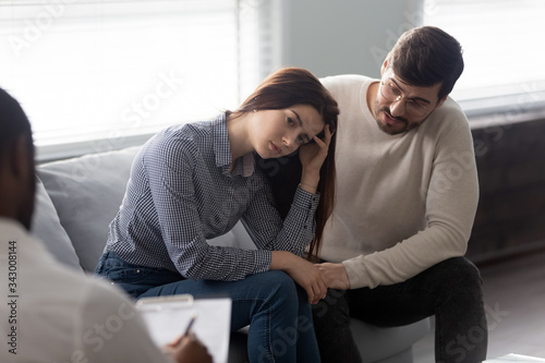 Disappointed man and woman at reception with family therapist. Husband talking with wife in bad mood. Family relationship disorder concept.
