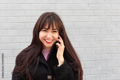 Happy girl talking on the phone in the street